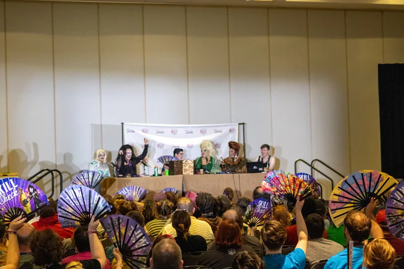 The audience at Gen Con 2025 waving the original Skill Check fans at the cast.