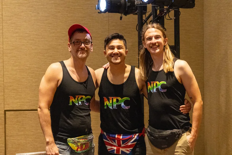 Three crew members in rainbow NPC tank tops.