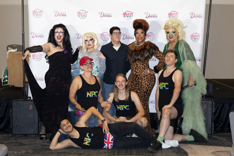 Cast and crew pose together in front of the Dragons, Dice and Divas step-and-repeat.