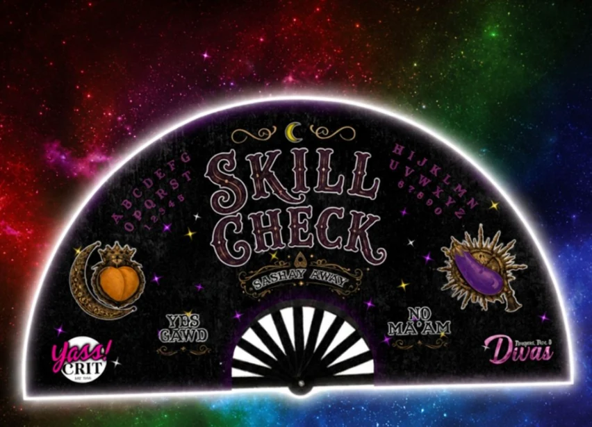 The Skill Check clack fan: a black ouija-board design with SKILL CHECK in the center, YES GAWD, NO MA&rsquo;AM and SASHAY AWAY, a peach and an eggplant, and the YassCrit and Divas logos.